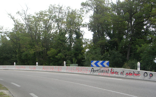 Slogans pro et anti IVG inscrits le long d'une route de campagne. Commune de Corbières, Alpes de Haute Provence (04), France