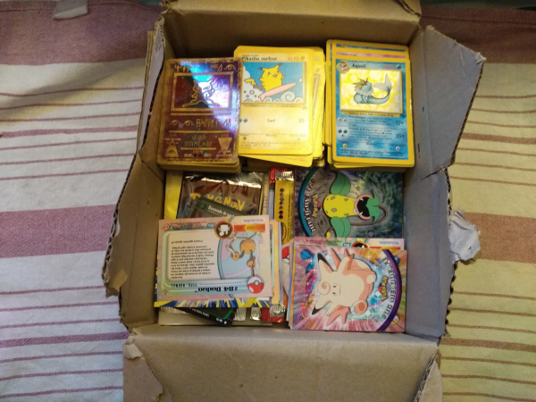 Photo de cartes Pokémon à jouer, de cartes Pokémon à collectionné et de booster ouvert, sur fond de torchon